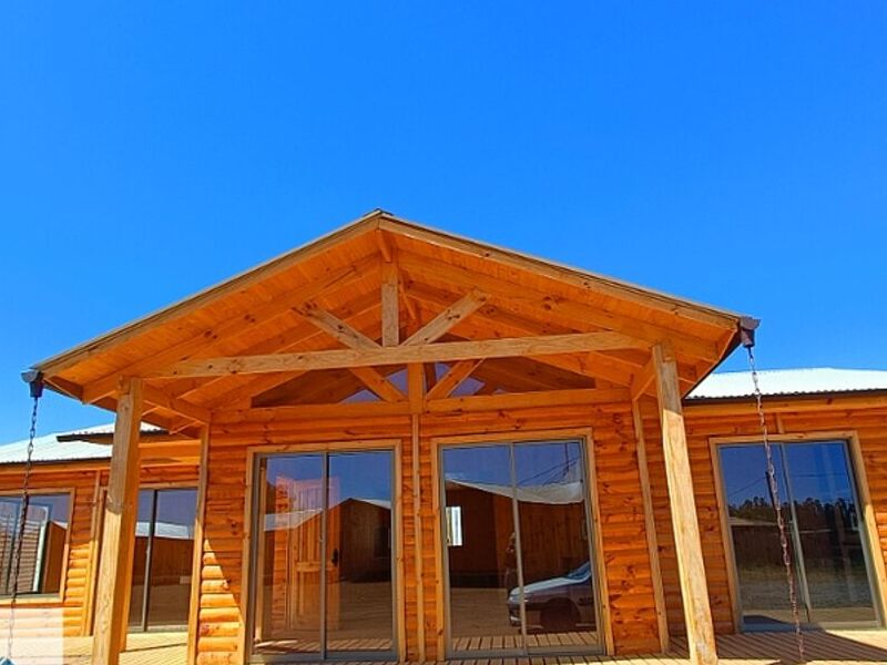 Cabaña de madera con pórtico de vigas a la vista